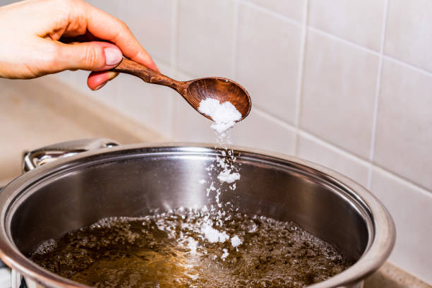 istock Adding salt in boiling water, cooking soup 915854602