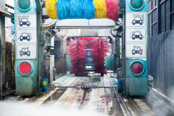 Photo of auto car wash machine spray soapy water to the car in the washing process