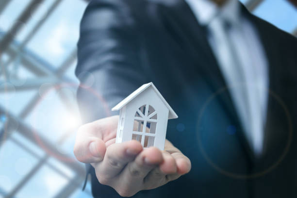 istock Real estate agent shows the house model . 915858090