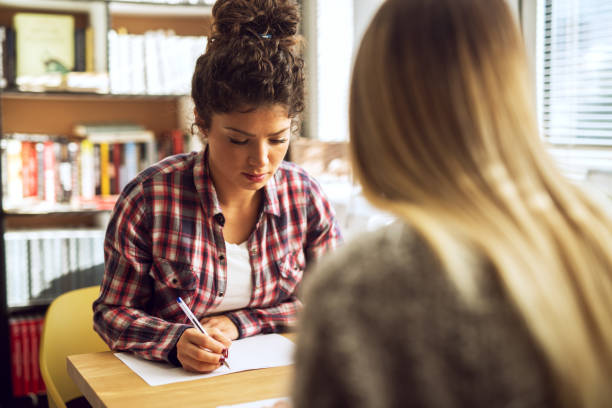 istock Female friends study at library. Preparing for exams. 915858416