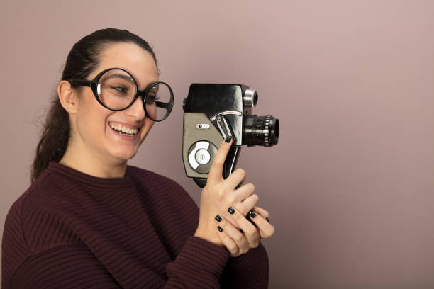 ビンテージ フィルム カメラを保持しているオタクの若い女性 - director film industry camera old fashioned ストックフォトと画像