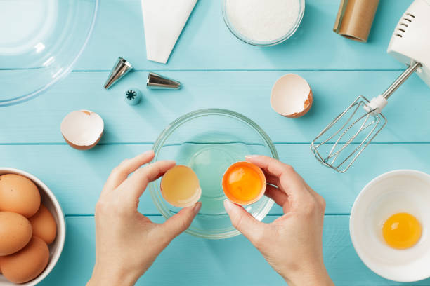 istock Female hands separate egg white from yolk for whipped cream. 915864422