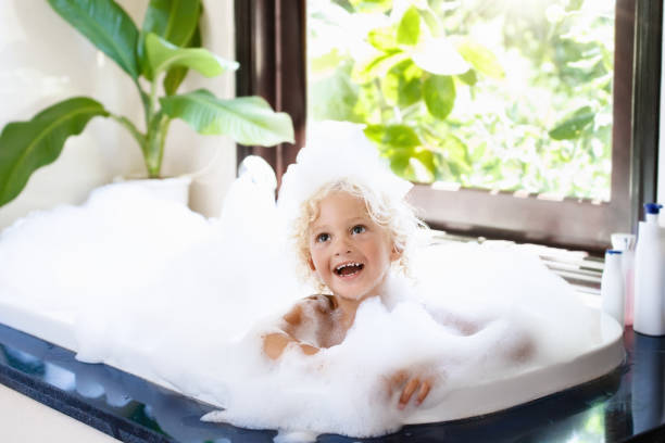 bambino in bagno di bolle. bagno per bambini. bambino sotto la doccia. - bathtub child bathroom baby foto e immagini stock