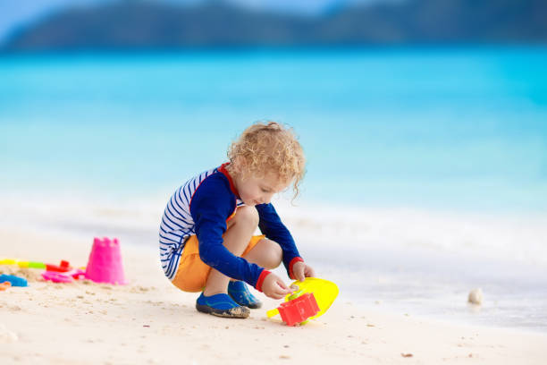 istock Kids play on tropical beach. Sand and water toy. 915875008