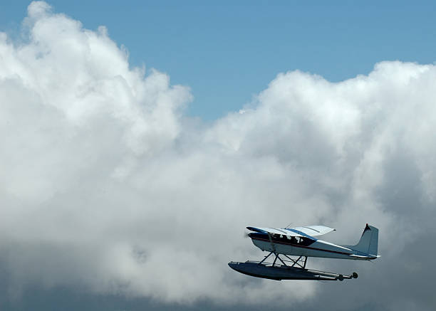 Small floatplane flying over mountains stock photo