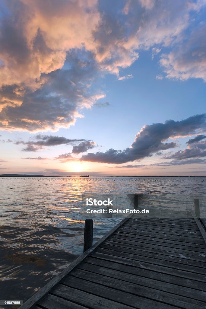 Poderoso Paisagem com nuvens e lakeside Pontão ao pôr do sol (XXL - Royalty-free Amanhecer Foto de stock