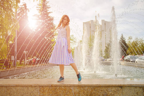 istock Dreamy girl by fountain 915876200