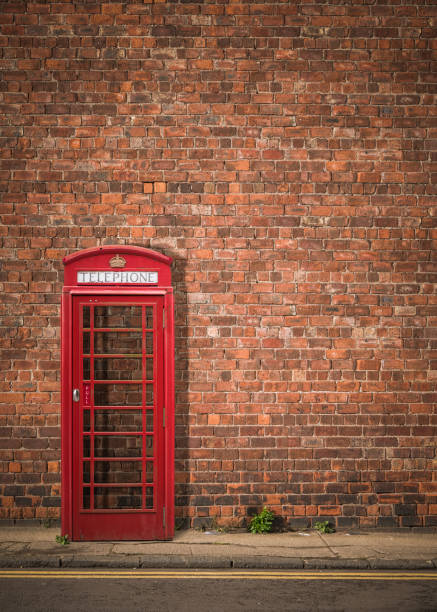 phonebox britannique contre le mur de brique rouge - pay phone brick wall telephone old photos et images de collection