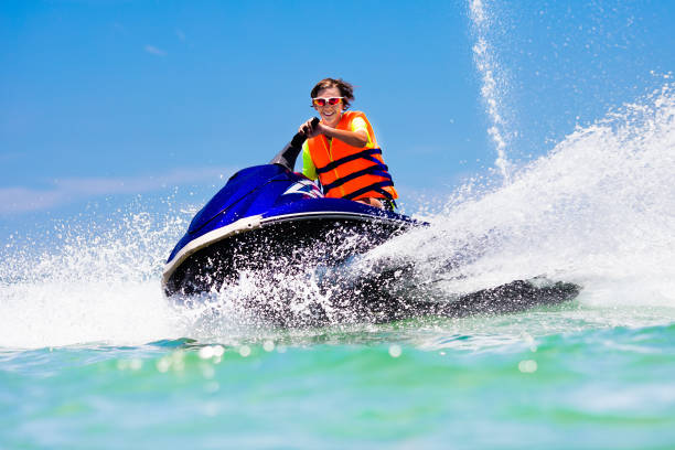 Teenager on jet ski. Teen age boy water skiing. Teenager on jet ski. Teen age boy skiing on water scooter. Young man on personal watercraft in tropical sea. Active summer vacation for school child. Sport and ocean activity on beach holiday. racing boat photos stock pictures, royalty-free photos & images