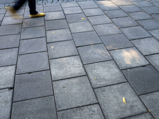 istock Feet with yellow shoes walking on grey sidewalk 915883214