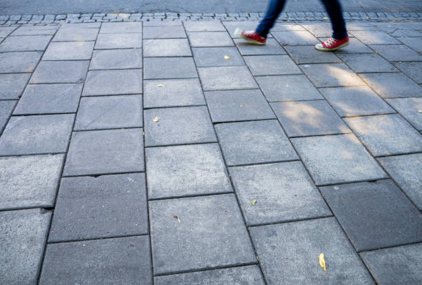 frauen mit roten schuhen und blaue jeans zu fuß schnell in der stadt - sidewalk walking human foot city stock-fotos und bilder