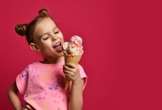 hübsches baby mädchen kind essen lecken große eis in waffeln kegel mit himbeer glücklich lachend - ice cream cone stock-fotos und bilder