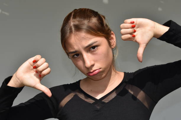 istock Beautiful Female With Thumbs Down 915889596