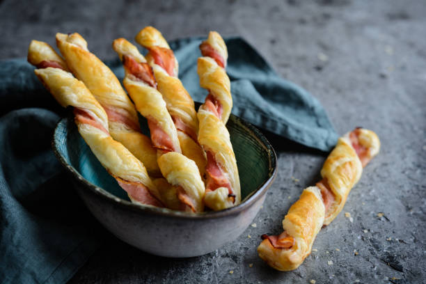 Twisted puff pastry sticks with bacon Twisted puff pastry sticks with bacon slices twisted bacon stock pictures, royalty-free photos & images