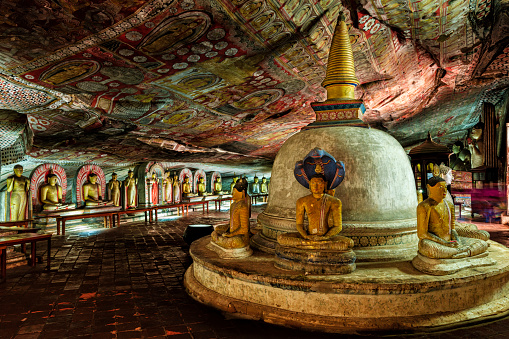 Buddha statue inside Dambulla cave temple, Sri Lanka. Dambulla cave temple also known as the Golden Temple of Dambulla is a World  Heritage Site in Sri Lanka, situated in the central part of the country. This site is situated 148 km east of Colombo and 72 km  north of Kandy. It is the largest and best-preserved cave temple complex in Sri Lanka. This temple complex dates back to the first century BCE. There are more than 80 documented caves in  the surrounding area. Major attractions are spread over 5 caves, which contain statues and paintings. These paintings and statues  are related to Lord Buddha and his life. There are total of 153 Buddha statues, 3 statues of Sri Lankan kings and 4 statues of  gods and goddesses.\n