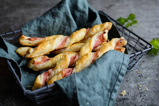 Twisted puff pastry sticks with bacon Twisted puff pastry sticks with bacon slices twisted bacon stock pictures, royalty-free photos & images