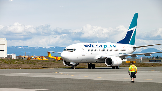 WestJet commercial 737 Boeing airplane landing  at the airport in Comox, British Columbia. It is arriving from Edmonton, Alberta. WestJet is the second largest airline in Canada.