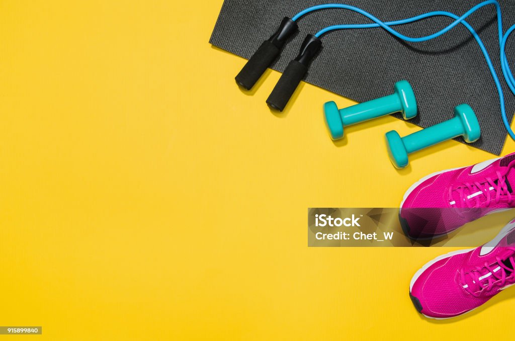 Fitness accessories on yellow background mock up, top view Fitness accessories, healthy and active lifestyles concept background with copy space for text. Products with vibrant, punchy pastel colours and frame composition. Image taken from above, top view. Exercising Stock Photo