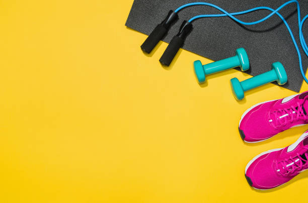 Fitness accessories on yellow background mock up, top view Fitness accessories, healthy and active lifestyles concept background with copy space for text. Products with vibrant, punchy pastel colours and frame composition. Image taken from above, top view. exercise equipment stock pictures, royalty-free photos & images