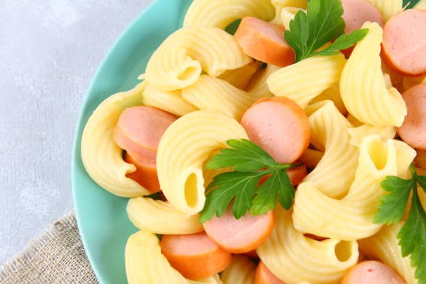 istock Pasta Cavatappi or Cellentani with sausages on a gray table. 915900954