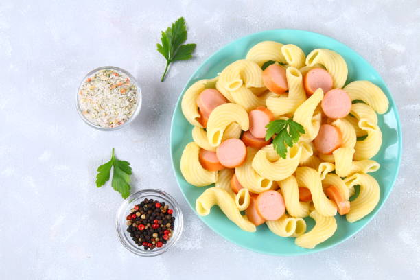 istock Pasta Cavatappi or Cellentani with sausages on a gray table. 915900980