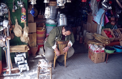 Jerusalem, Israel, 1976. A merchant in the Arab quarter of the Old City of Jerusalem is taking a nap in a chair. It is noteworthy that the market trader has put on his shirt sleeves on both chair legs of the backrest. Thus, he can not fall from the chair and fully indulge his afternoon nap.