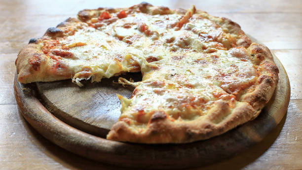 istock Hot pizza slice with melting cheese on a rustic wooden table background, Foods concept. 915904262