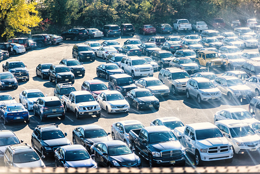 Kearny: View of New Jersey car parking lot with many shiny cars, reflection on bright sunlight flare rays