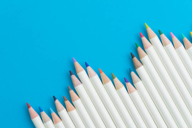 istock Colour pencils on blue paper background with copy space using as colouring or art concept 915908290