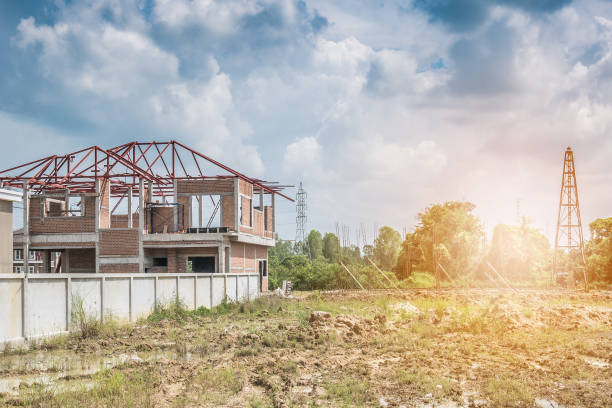 istock Residential new house building at construction site with clouds and blue sky 915911444