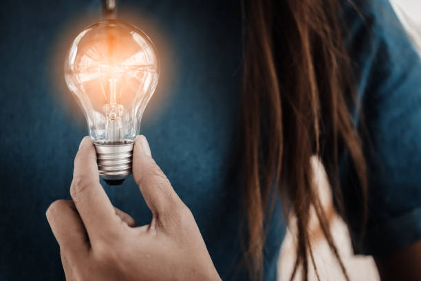 woman hand hold light bulb creativity ideas concept - illusion efficiency light bulb energy imagens e fotografias de stock