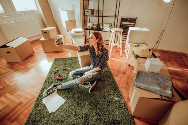 junge frau umzug in eine neue wohnung. nehmen eine selfie liegend auf einem teppich - carpet floor lying down people stock-fotos und bilder