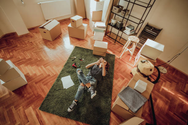 junge frau umzug in eine neue wohnung. gespräch mit einem freund auf einem teppich liegend - carpet floor lying down people stock-fotos und bilder