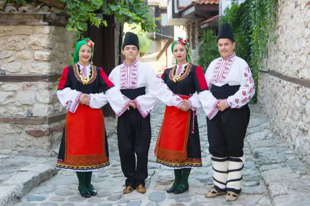 Photo of Beautiful young people in national costumes. Concept of identity preservation.