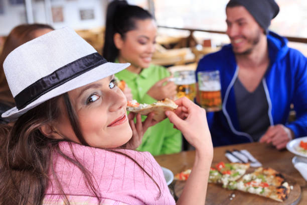 istock Young people eating pizza in restaurant 915923672
