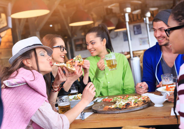 istock Young people eating pizza in restaurant 915923680