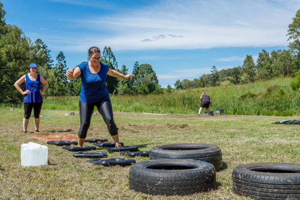 istock Women Completing Obstacle Course at Outdoor Training Session 915933868