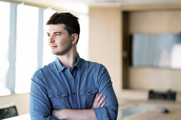 istock Thoughtful businessman standing with arms crossed 915946428