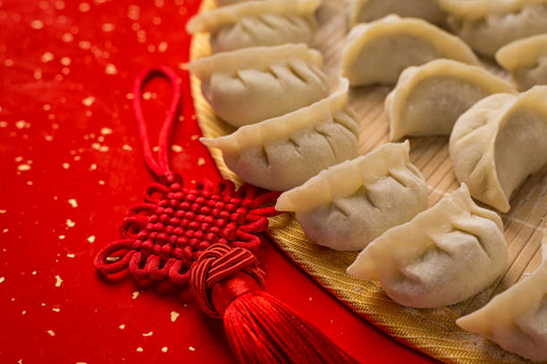 istock dumplings and Chinese kont on the red paper with white space 915946914