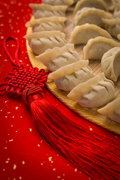 istock dumplings and Chinese kont on the red paper with white space 915947014