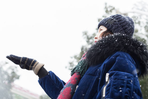 beautiful woman enjoying snow falling,China.