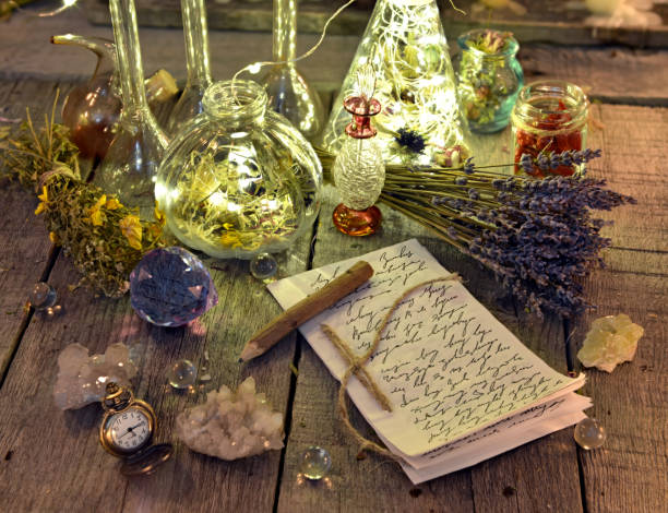 istock Witch manuscript with writings, magic bottles, crystals and lavender flowers on planks 915966620