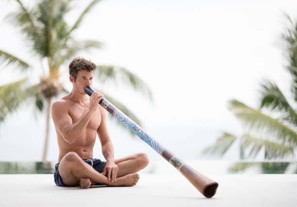 Man Playing Didgeridoo Man playing a didgeridoo, Australia. didgeridoo stock pictures, royalty-free photos & images