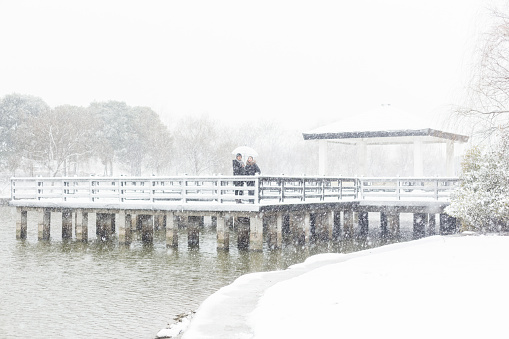 Snow-covered pier on the lake on a foggy day, winter view in the eastern Poland