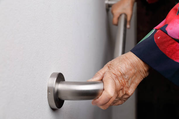 istock Elderly woman holding on handrail for safety walk steps 915969414