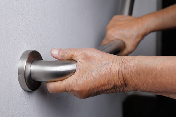 istock Elderly woman holding on handrail for safety walk steps 915969446
