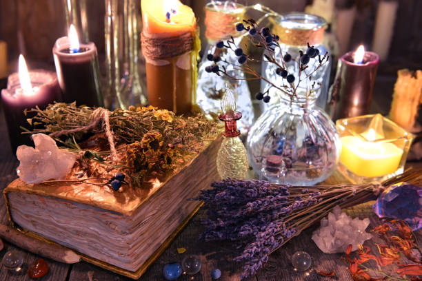 istock Witch ritual collection with old spelling book, lavender, bottles, herbs and magic objects 915969562