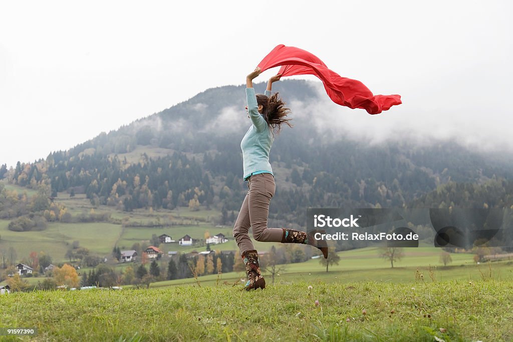 Mulher com Lenço vermelho Salto de alegria na área de Montanha - Royalty-free Adulto Foto de stock