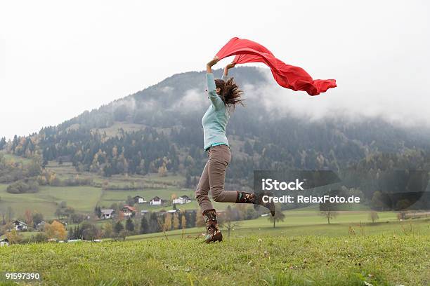 Mulher Com Lenço Vermelho Salto De Alegria Na Área De Montanha - Fotografias de stock e mais imagens de Adulto