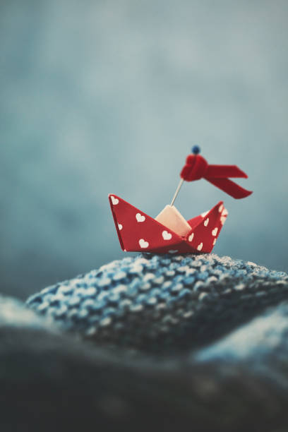istock Handmade origami love boat on handmade waves 915974608